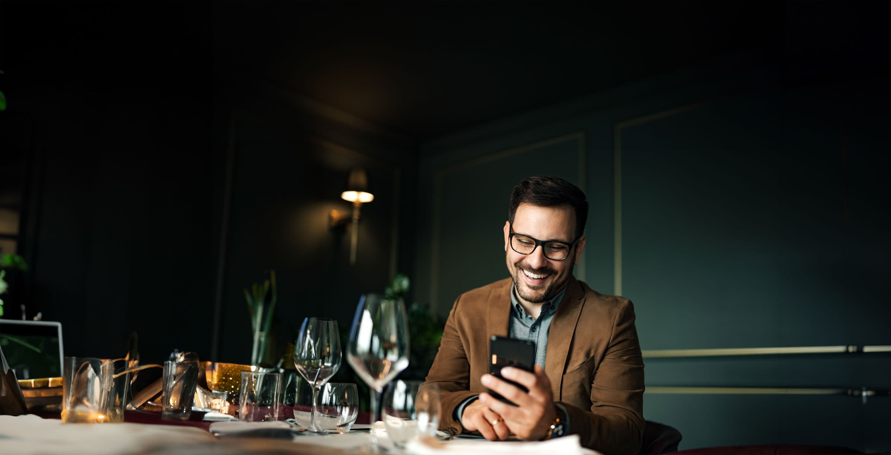 Mies katsomassa nauraen puhelinta